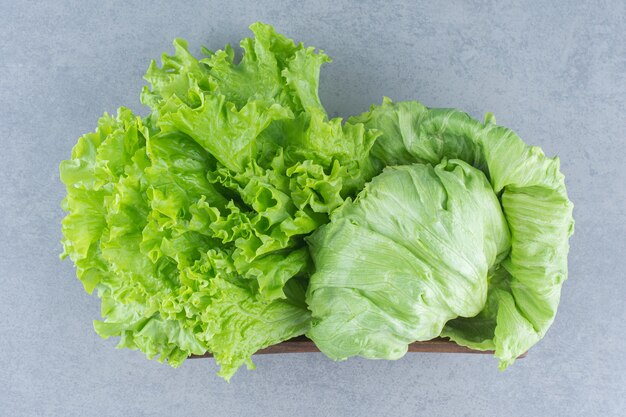 Nahaufnahmefoto Salatblätter auf dem grauen Hintergrund im Korb.