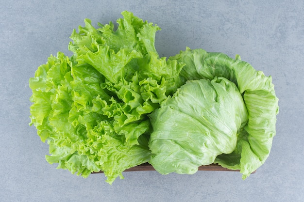 Nahaufnahmefoto Salatblätter auf dem grauen Hintergrund im Korb.