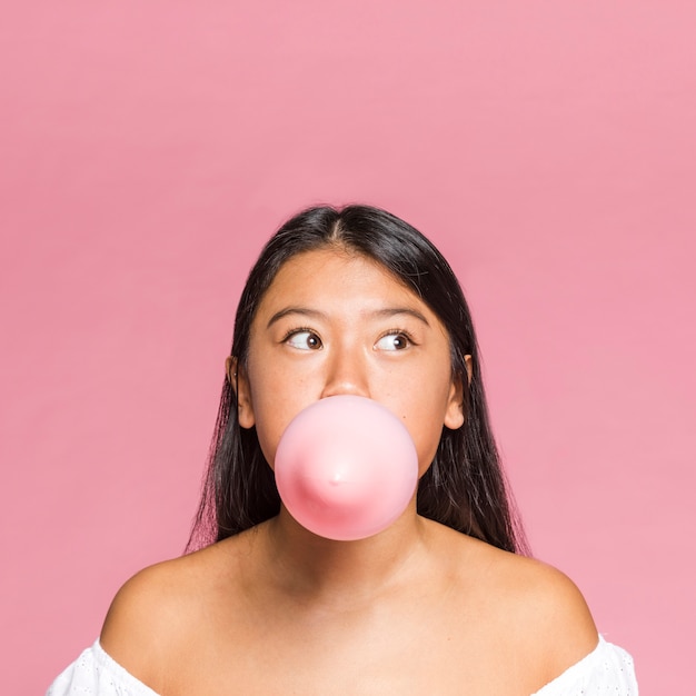 Kostenloses Foto nahaufnahmefrau bläst einen rosa ballon auf