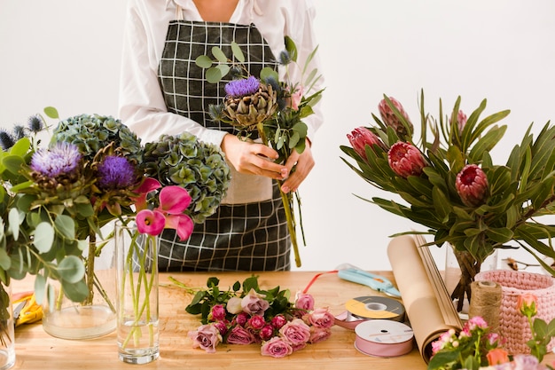 Nahaufnahmefrau, die am Blumenspeicher arbeitet