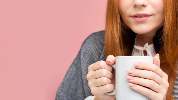 Nahaufnahmefrau, die Becher hält