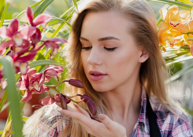 Nahaufnahmefrau, die Blumen betrachtet