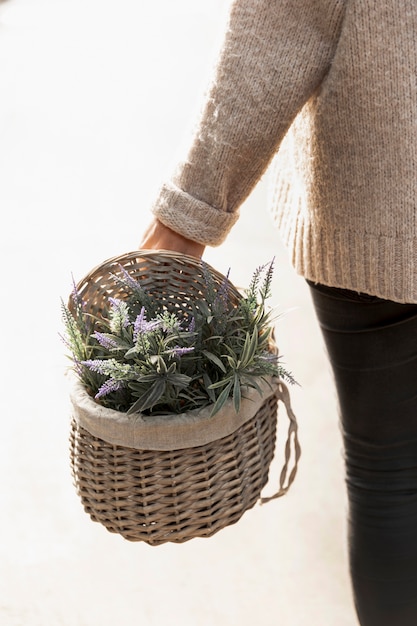 Nahaufnahmefrau, die Blumenkorb hält