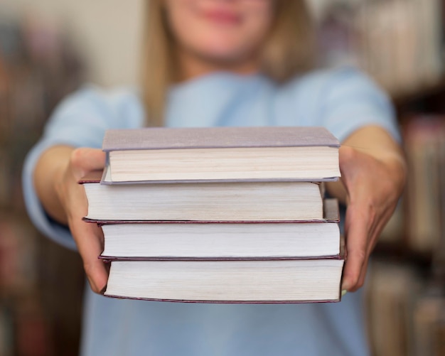 Kostenloses Foto nahaufnahmefrau, die bücher hält