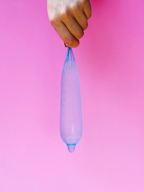 Nahaufnahmefrau, die ein gefülltes Kondom hält