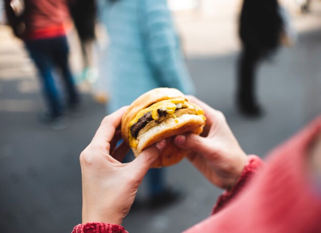 Nahaufnahmefrau, die geschmackvollen Burger hält