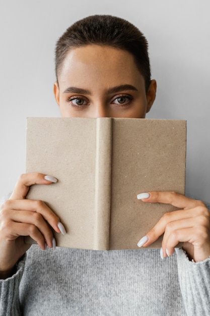 Kostenloses Foto nahaufnahmefrau, die gesicht mit notizbuch bedeckt