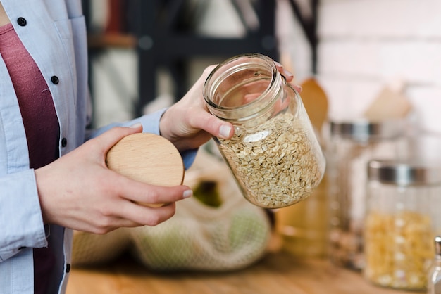 Nahaufnahmefrau, die Glas mit Müsli hält