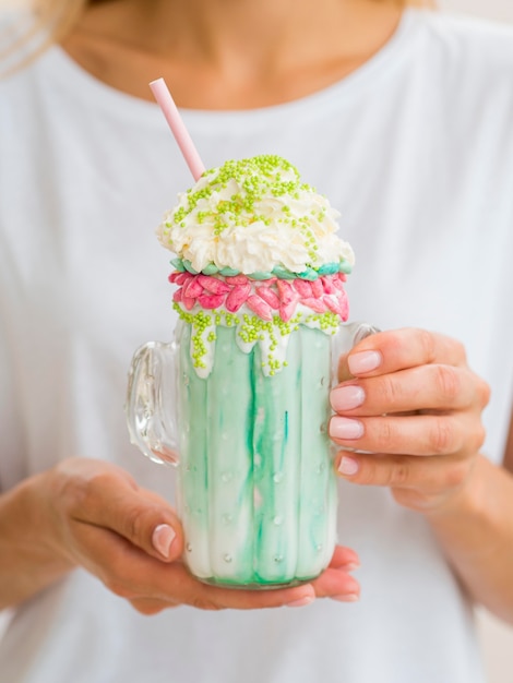 Nahaufnahmefrau, die Milchshake hält