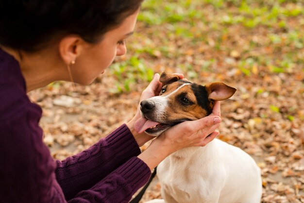 Nahaufnahmefrau, die mit ihrem Hund spielt