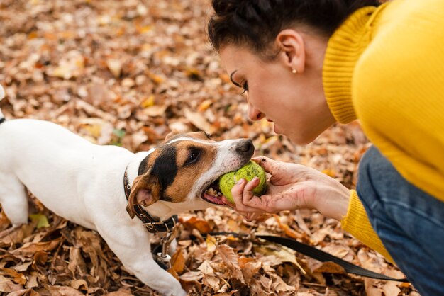 Nahaufnahmefrau, die mit ihrem Hund spielt