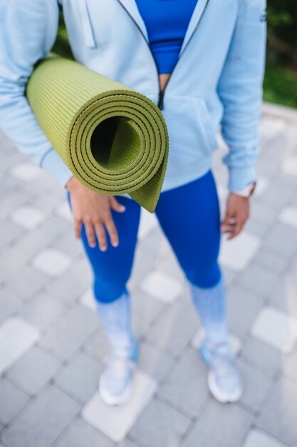 Nahaufnahmefrau, die Rollfitness nach der Arbeit hält