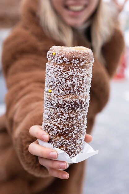 Nahaufnahmefrau, die Schornsteinkuchen hält