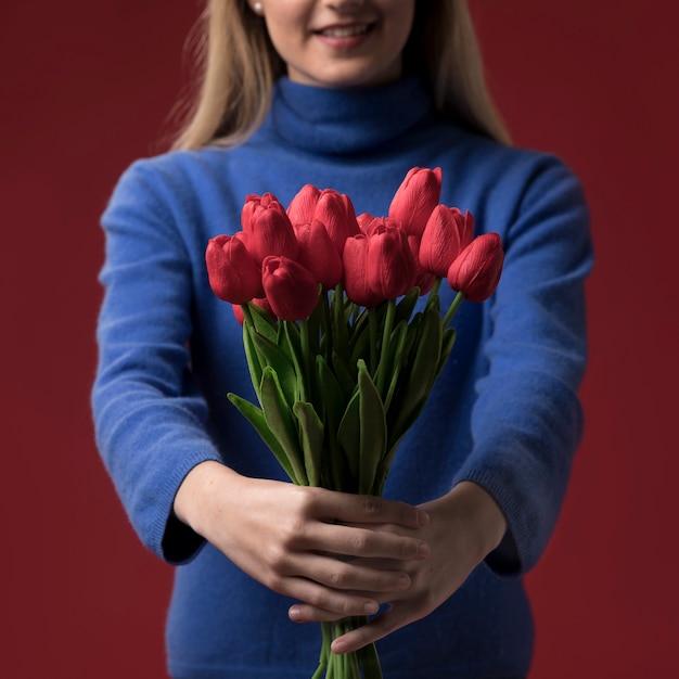 Nahaufnahmefrau, die Tulpen hält