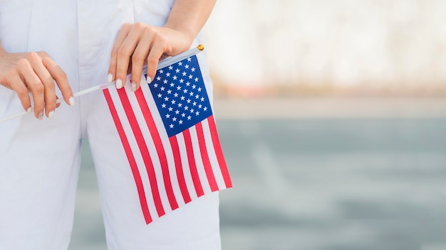 Nahaufnahmefrau, die USA-Flagge in Händen hält