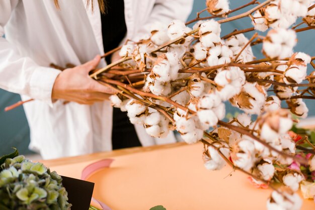 Nahaufnahmefrau mit dem Laborkittel, der Blumen hält