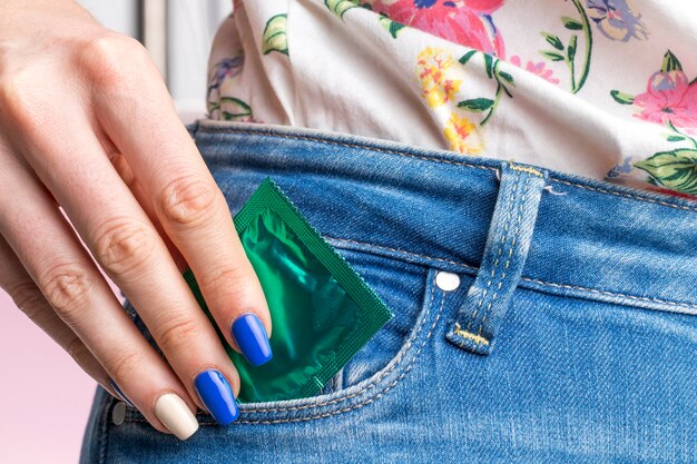 Nahaufnahmefrau mit Kondom in ihrer Tasche