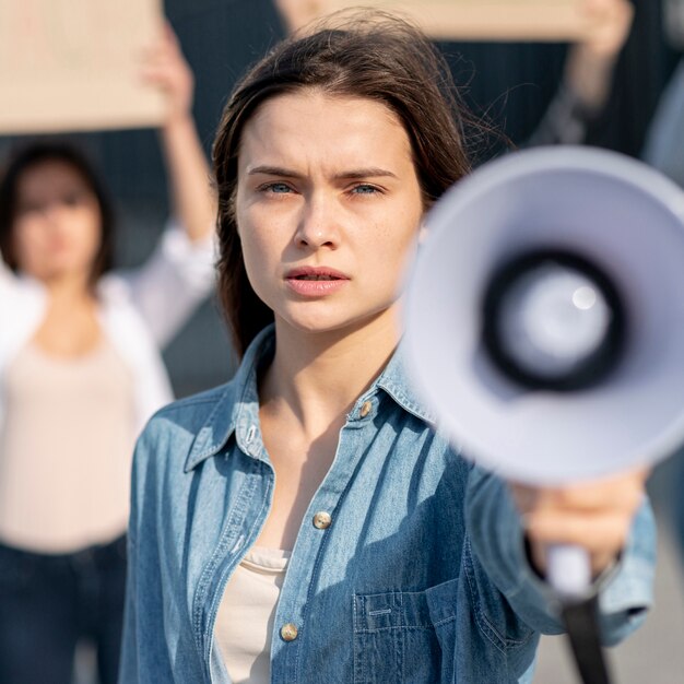 Nahaufnahmefrau mit Megaphon an der Demonstration