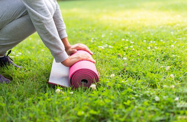 Nahaufnahmefrau mit rosa Yogamatte