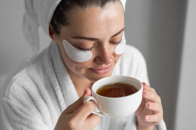 Nahaufnahmefrau mit Teetasse hohem Winkel