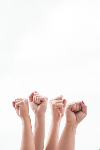 Nahaufnahmefrauen, die Fäuste bei der Versammlung hochhalten