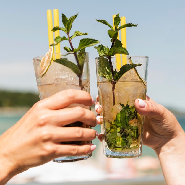 Nahaufnahmefrauen, die Sommercocktails genießen