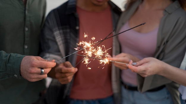 Nahaufnahmefreunde, die funkelndes Feuerwerk halten