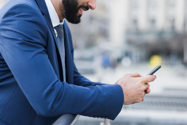 Nahaufnahmegeschäftsmann, der Telefon verwendet