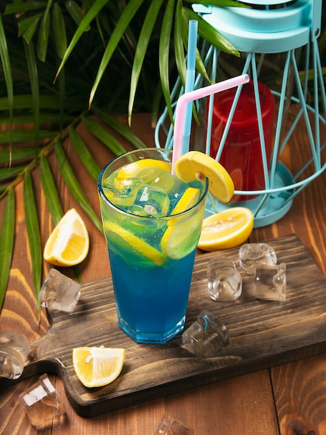 Nahaufnahmeglas des blauen Lagunencocktails verziert mit Kalk am festlichen Barzähler.