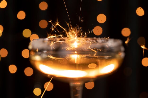 Nahaufnahmeglas mit Champagner und goldenen Lichtern
