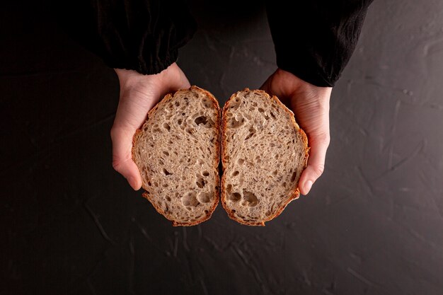 Nahaufnahmehände, die Brot Draufsicht halten