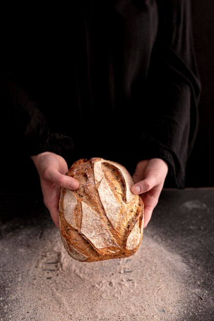 Nahaufnahmehände, die frisches Brot halten