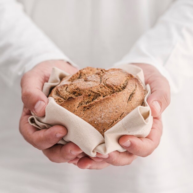 Nahaufnahmehände, die kleines Brot halten