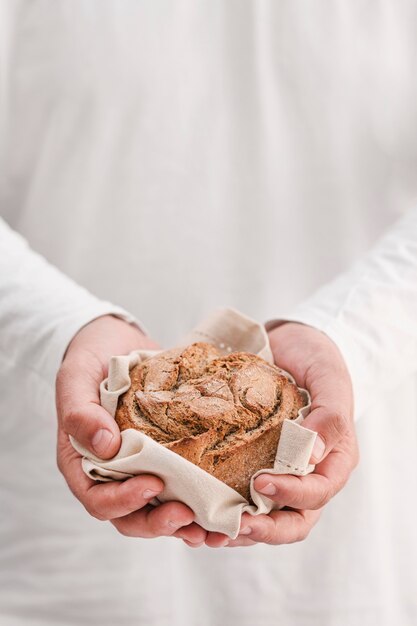 Nahaufnahmehände, die kleines Brot halten