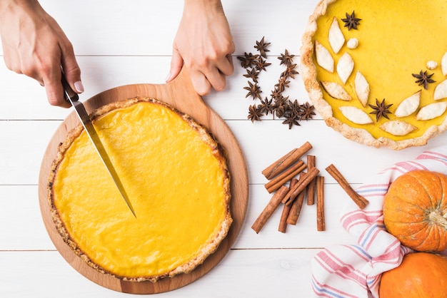 Nahaufnahmehände, die leckeren Kuchen schneiden