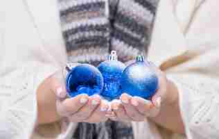 Kostenloses Foto nahaufnahmehände, die weihnachtsbälle halten