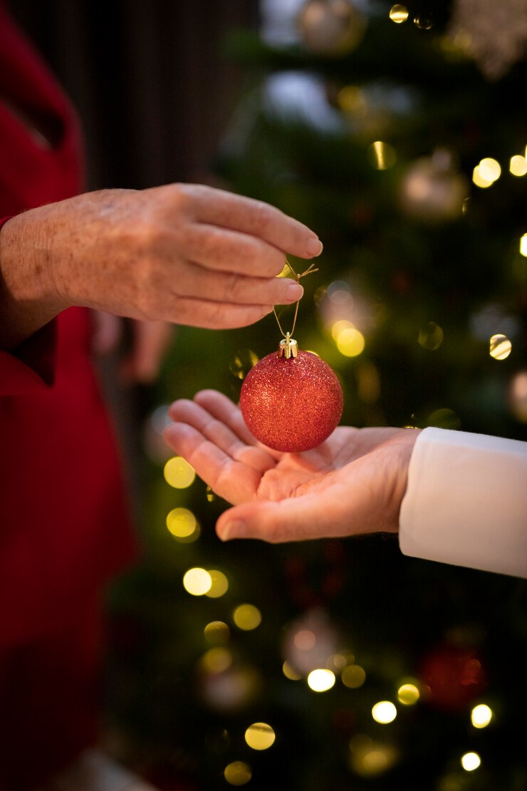 Kostenlose Foto nahaufnahmehände, die weihnachtsball halten