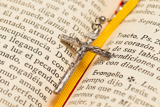 Nahaufnahmehalskettenkreuz und Heilige Schrift