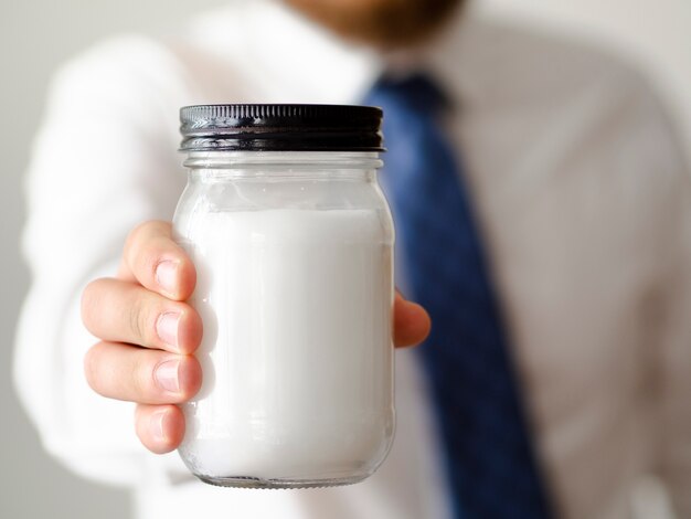 Nahaufnahmehand, die ein Glas Zuckermodell hält