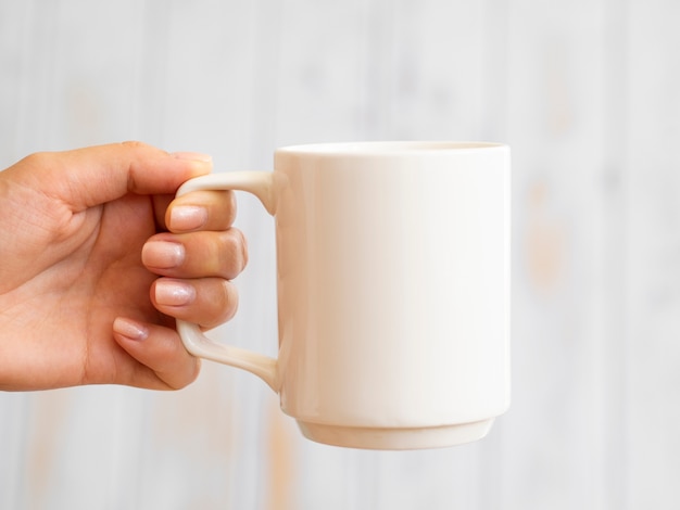 Kostenloses Foto nahaufnahmehand, die einen becher hält