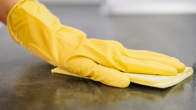 Nahaufnahmehand, die gelben Handschuh trägt