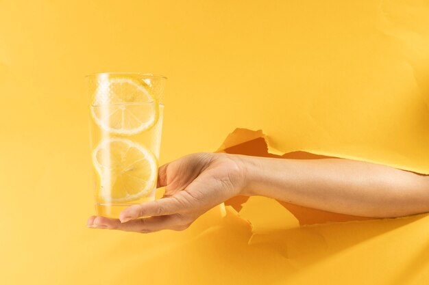 Nahaufnahmehand, die Glas Limonade hält