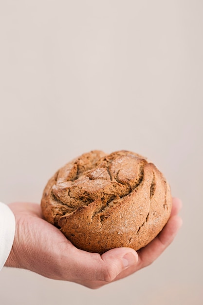 Nahaufnahmehand, die kleines Brot hält