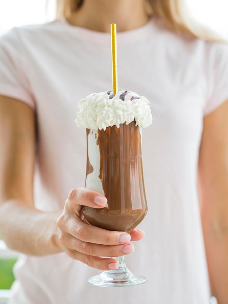 Nahaufnahmehand, die Schokoladenmilchshake hält