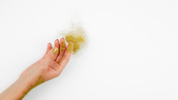 Nahaufnahmehand mit goldenem Funkeln