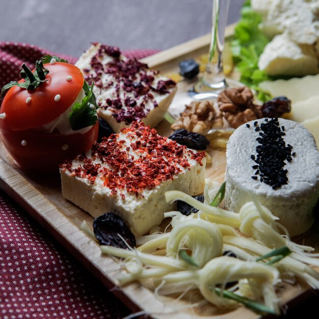 Nahaufnahmekäse, der verschiedene Arten von Käsemuss-Rosinen-Tomaten schneidet