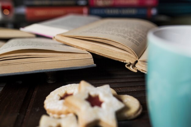 Nahaufnahmekekse und -becher nahe Büchern