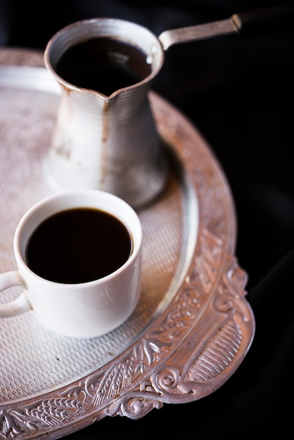 Nahaufnahmekessel und -kaffee auf einer silbernen Platte