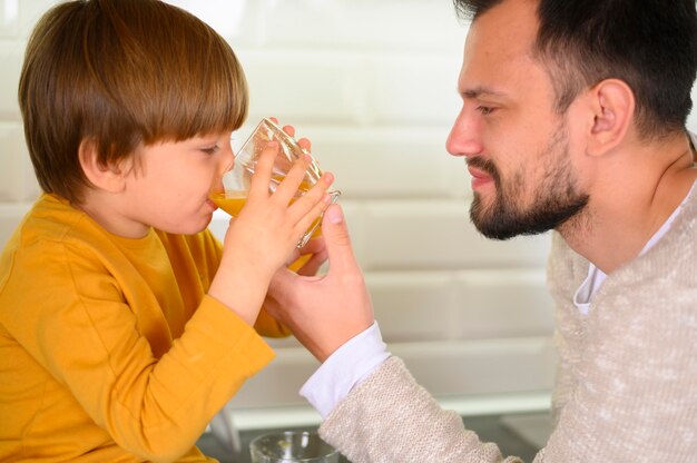 Nahaufnahmekind, das Orangensaft trinkt