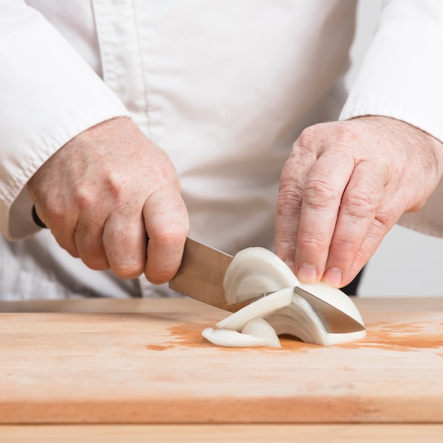 Nahaufnahmekoch, der Zwiebel schneidet